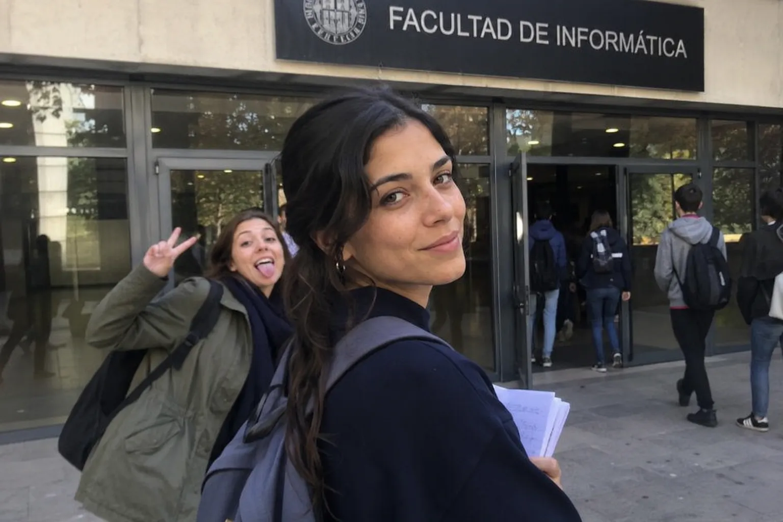 Luc&iacute;a entrando en la Facultad de Inform&aacute;tica con Marta haciendo el payaso detr&aacute;s